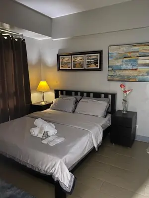 a bedroom with a bed with towels on it at JNL Condotel in Manila