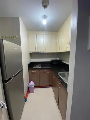 a small kitchen with a refrigerator and a sink at JNL Condotel in Manila