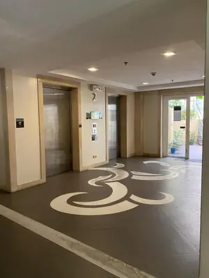an empty lobby with a spiral painted on the floor at JNL Condotel in Manila