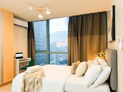 a bedroom with a white bed with a large window at Prime 1br Condo Infront Grand Hyatt BGC #oursw20d1 in Manila