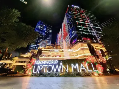a building with a sign that reads metropolitan uptown mall at night at Prime 1br Condo Infront Grand Hyatt BGC #oursw20d1 in Manila