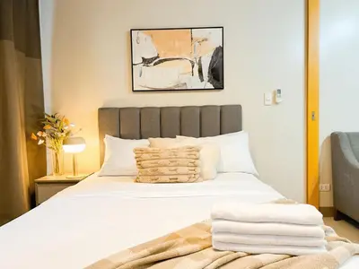 a bedroom with a large white bed with towels on it at Prime 1br Condo Infront Grand Hyatt BGC #oursw20d1 in Manila
