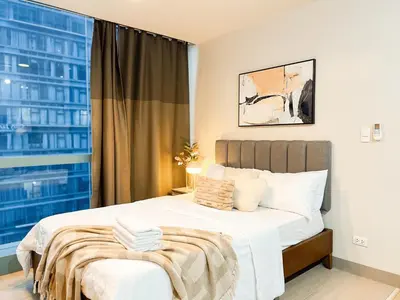 a bedroom with a large bed with a window at Prime 1br Condo Infront Grand Hyatt BGC #oursw20d1 in Manila