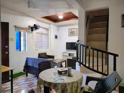 a living room with a table and a living room at Simple, Spacious Home To Stay, 2Bedrooms 2 Toilet & Bath 1 car garage in Uldugan
