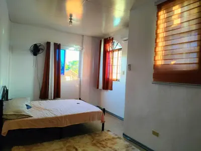 a bedroom with a bed and a window at Simple, Spacious Home To Stay, 2Bedrooms 2 Toilet & Bath 1 car garage in Uldugan