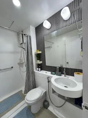 a bathroom with a sink and a toilet and a mirror at Condo in Malate in Manila