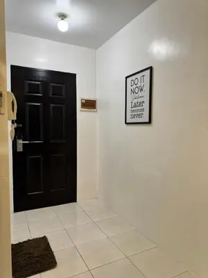 a black door and a sign on a white wall at Condo in Malate in Manila