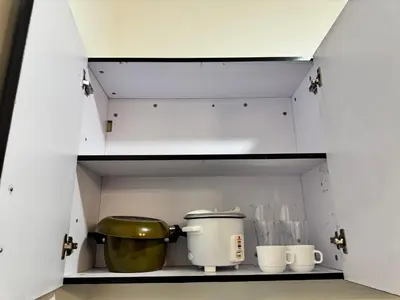 a kitchen shelf with a large pot and cups at Condo in Malate in Manila