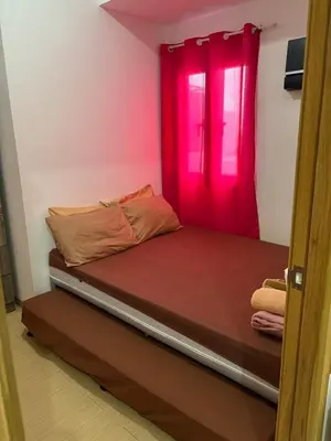 a bed with a red window in a room at Urban haven Family&Barkada room in Manila
