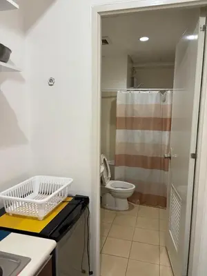 a bathroom with a toilet and a shower and a sink at Urban haven Family&Barkada room in Manila