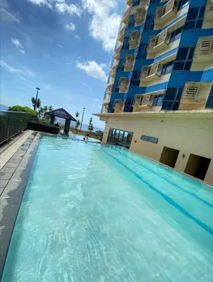 a swimming pool in front of a building at Urban haven Family&Barkada room in Manila