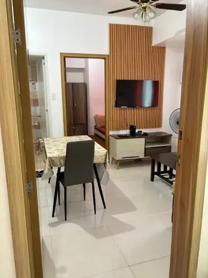 a living room with a table and a television at Urban haven Family&Barkada room in Manila