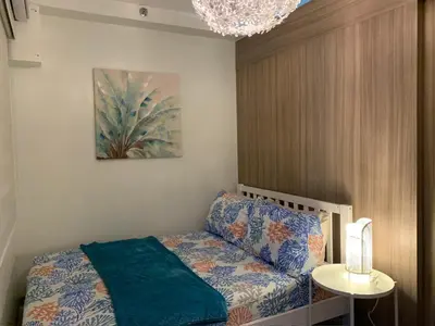 a bedroom with a bed and a chandelier at Tropical Sanctuary in Pasay City in Manila