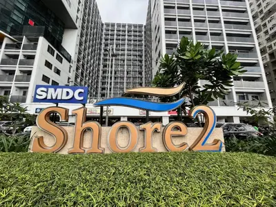 a sign in the grass in front of some buildings at Tropical Sanctuary in Pasay City in Manila