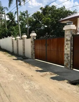 a house with a fence and a dirt road at Villa Ariana Family Getaway in Bukal