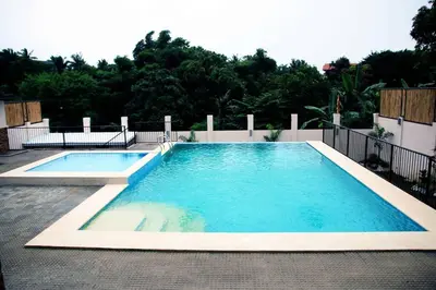 a large swimming pool with blue water at Villa Ariana Family Getaway in Bukal