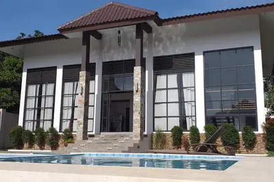 a house with a swimming pool in front of it at Villa Ariana Family Getaway in Bukal