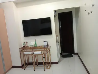 a living room with a table and a television on a wall at Newport 101 - East Wing in Manila