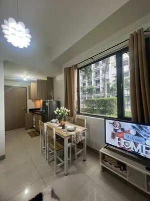 a living room with a television and a table with chairs at StayWise Space Manila in Manila