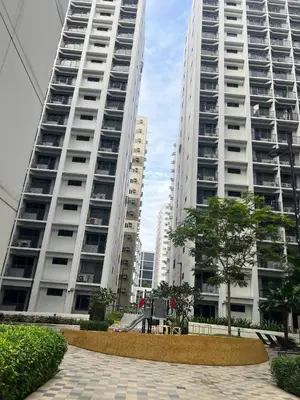 two tall white buildings with trees in front of them at StayWise Space Manila in Manila