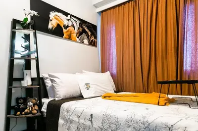 a bedroom with a bed and a horse picture on the wall at Comfortable 2-Bedroom Home in Paranaque in Manila