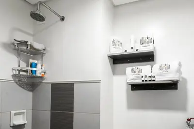 a bathroom with a shower and a towel rack at Comfortable 2-Bedroom Home in Paranaque in Manila