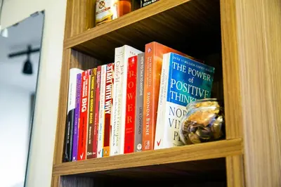 a book shelf with many books on it at Comfortable 2-Bedroom Home in Paranaque in Manila