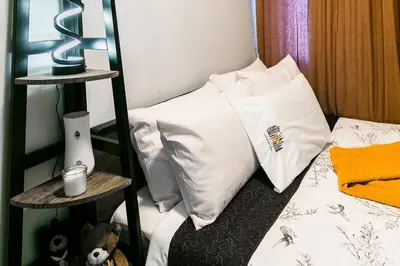 a bedroom with a bed with white pillows at Comfortable 2-Bedroom Home in Paranaque in Manila