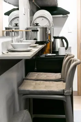 a counter with a chair in a kitchen with dishes at Comfortable 2-Bedroom Home in Paranaque in Manila
