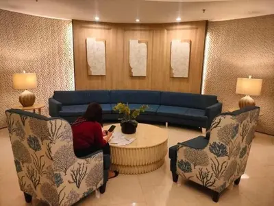 a woman sitting at a table in a living room at Shell Residences in Manila