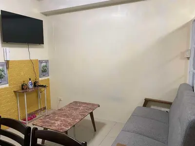 a living room with a table and a couch at Shore Residences C1 in Manila