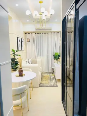 a living room with a white table and a couch at NEAR NAIA TERMINAL 1, 2, 3 Cozy Apartment at Field Residence in Manila