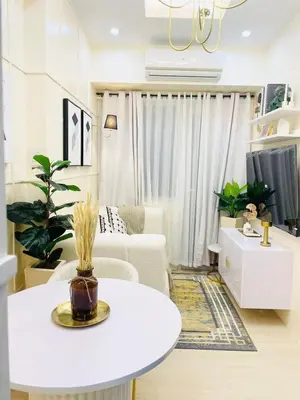 a living room with a white table and a couch at NEAR NAIA TERMINAL 1, 2, 3 Cozy Apartment at Field Residence in Manila