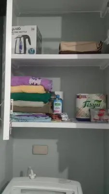 a shelf with towels and other items in a bathroom at Josephine Macatula in Santa Rosa