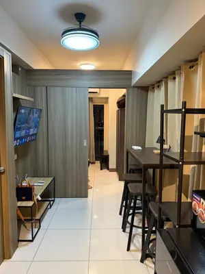 a room with a table and chairs and a television at 2 bedroom Haven in Manila
