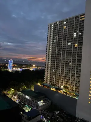 a tall building at night with a ferris wheel in the background at 2 bedroom Haven in Manila