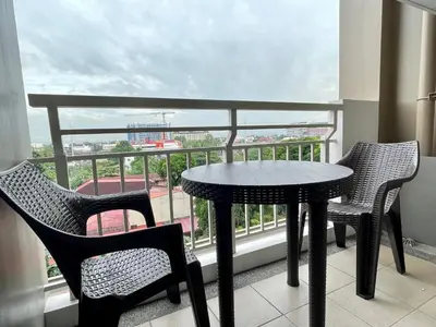a table and chairs on a balcony with a view at Satori Residences in Manila