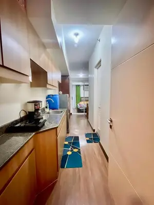 a kitchen with a counter top and a room with a door at Satori Residences in Manila