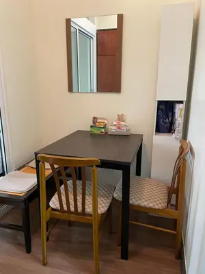 a dining room table with two chairs and a mirror at Satori Residences in Manila