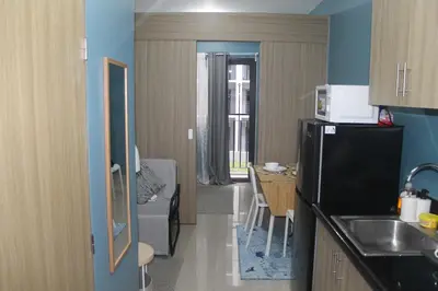 a small kitchen with a refrigerator and a table at Shore 2 Residence Tower 2 in Manila