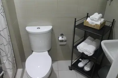 a bathroom with a toilet and a sink and towels at Shore 2 Residence Tower 2 in Manila