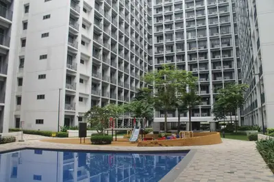 an apartment complex with a pool in front of a building at Shore 2 Residence Tower 2 in Manila