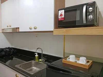 a kitchen with a sink and a microwave at Homefort Twin Bed Suite - Red Residences Makati 1146 in Manila