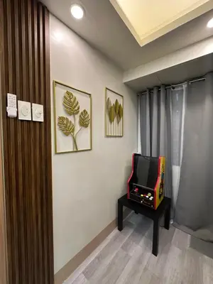a living room with a tv and a tv console at Modern and Cozy Suite at Shore Residences in Manila