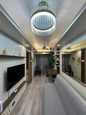 a living room with a television and a chandelier at Modern and Cozy Suite at Shore Residences in Manila