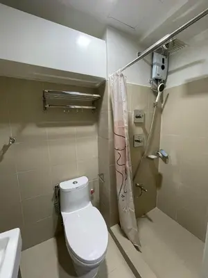 a small bathroom with a toilet and a shower at Modern and Cozy Suite at Shore Residences in Manila