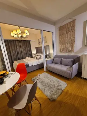 a hotel room with a bed and a table and chairs at Staycation in Mandaluyong near Makati and BGC in Manila