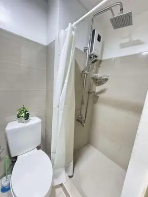 a small bathroom with a toilet and a shower at lhey's staycation in Manila
