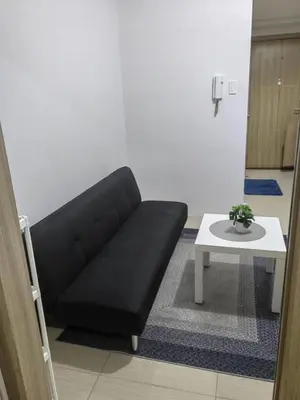 a black couch in a living room with a table at lhey's staycation in Manila