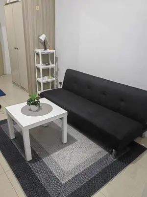 a black couch and a coffee table in a living room at lhey's staycation in Manila